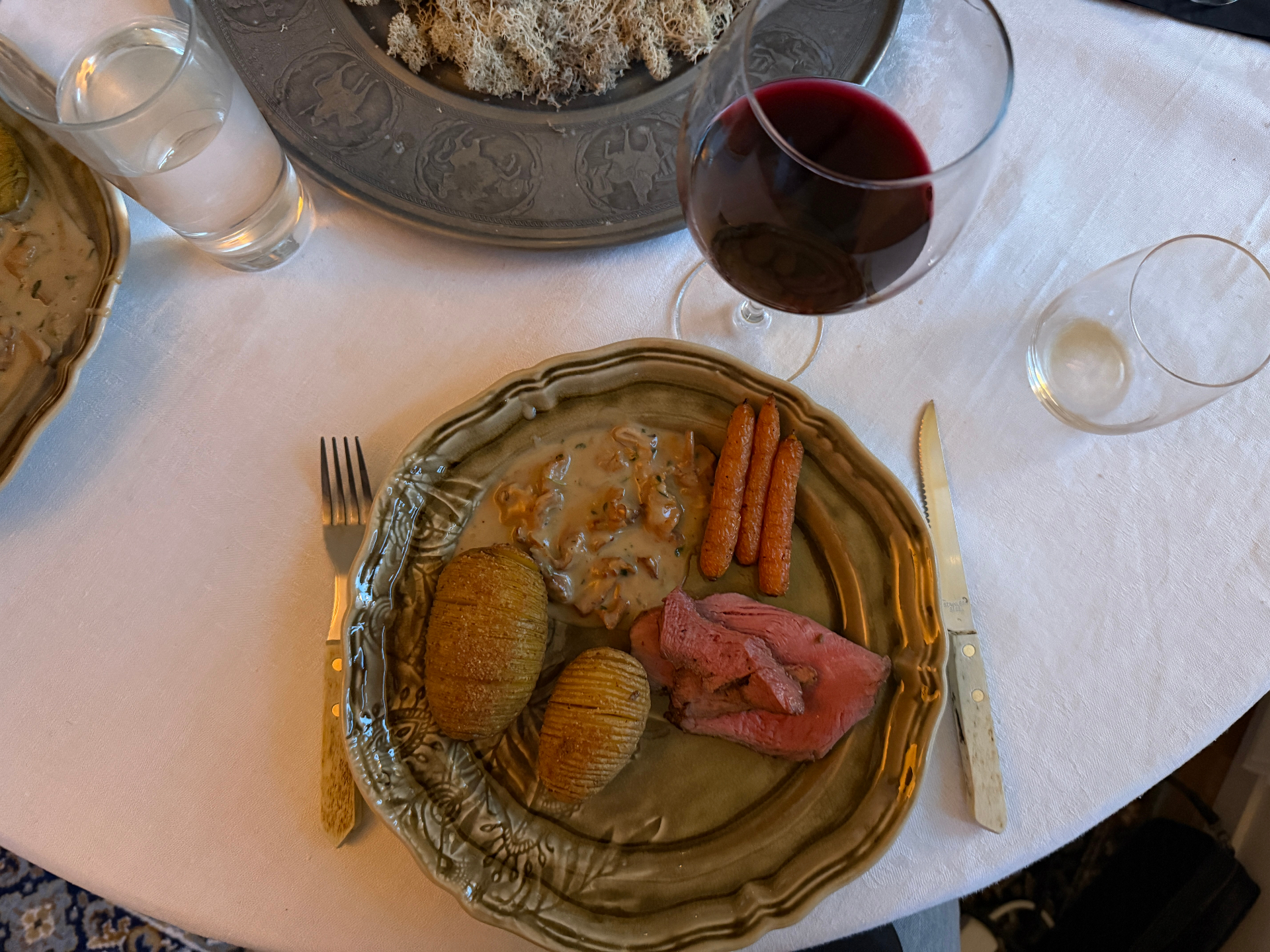 Beef with hasselback potatoes, carrots, mushroom sauce, red wine