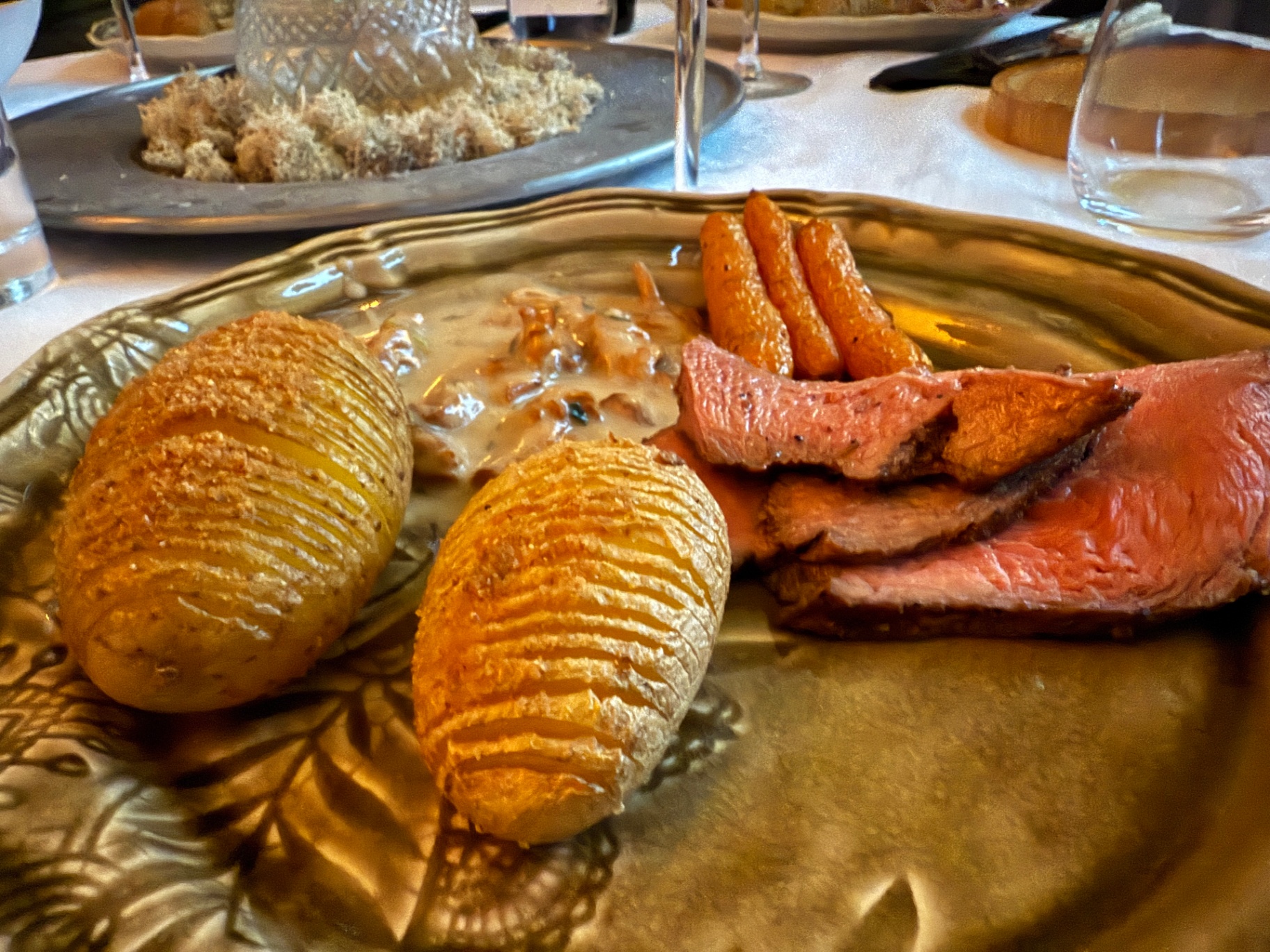 Hasselback potatoes and pink beef close-up